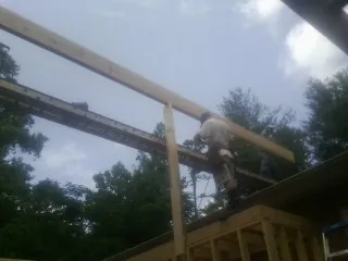 Carpenter setting a ridge beam over a new addition frame — Ice Dam Removal by Roofing Brothers in Monmouth