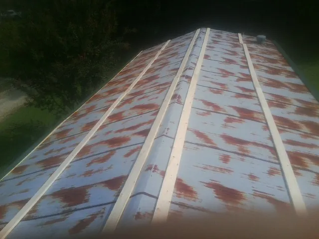 Rusted metal roof panels with new wood purlins before replacement — Storm Damage Roof Repair in Monmouth by Roofing Brothers