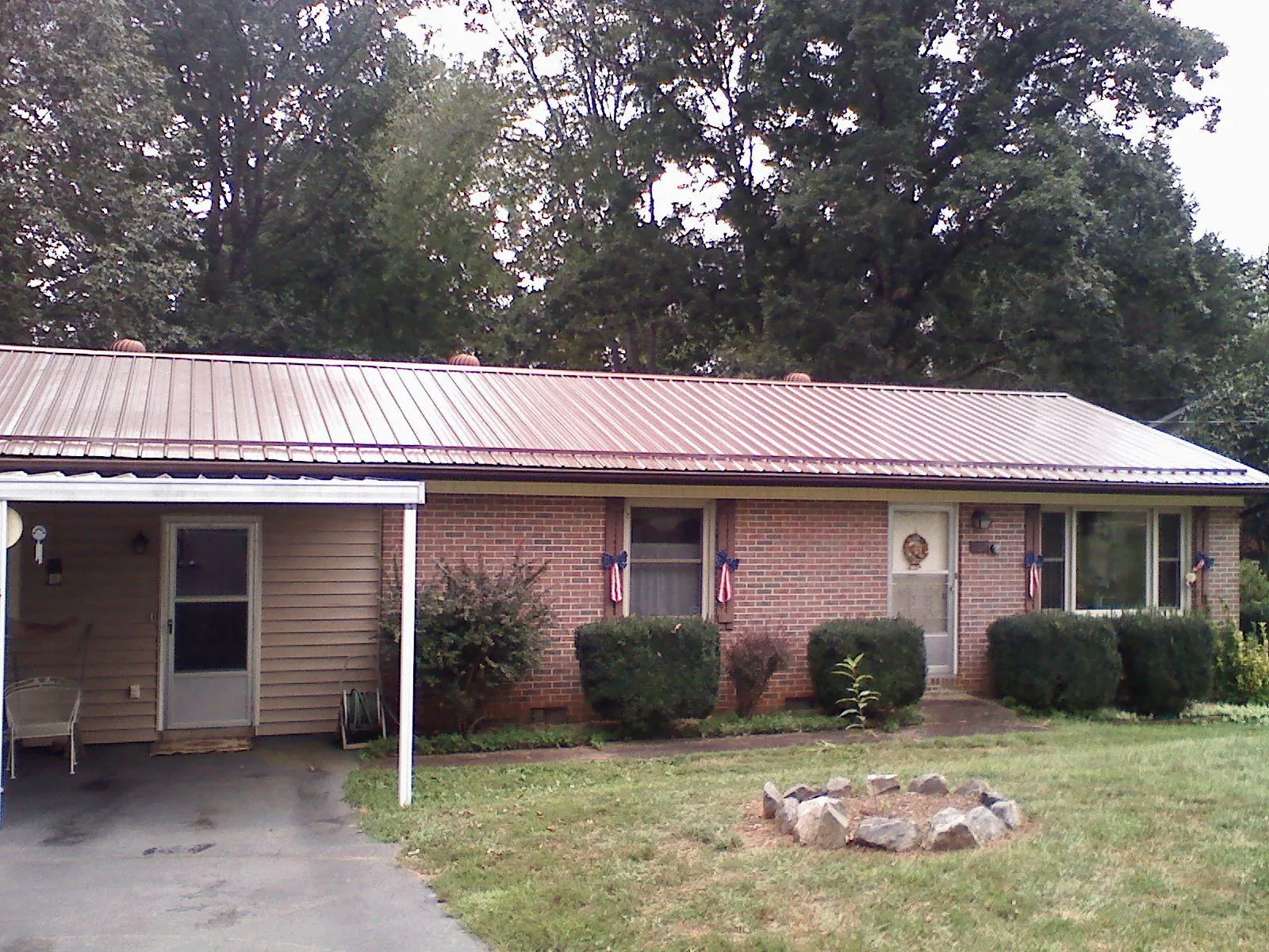 Bronze metal roof and carport on a brick ranch home — Roof Repair work by our crew in Monmouth